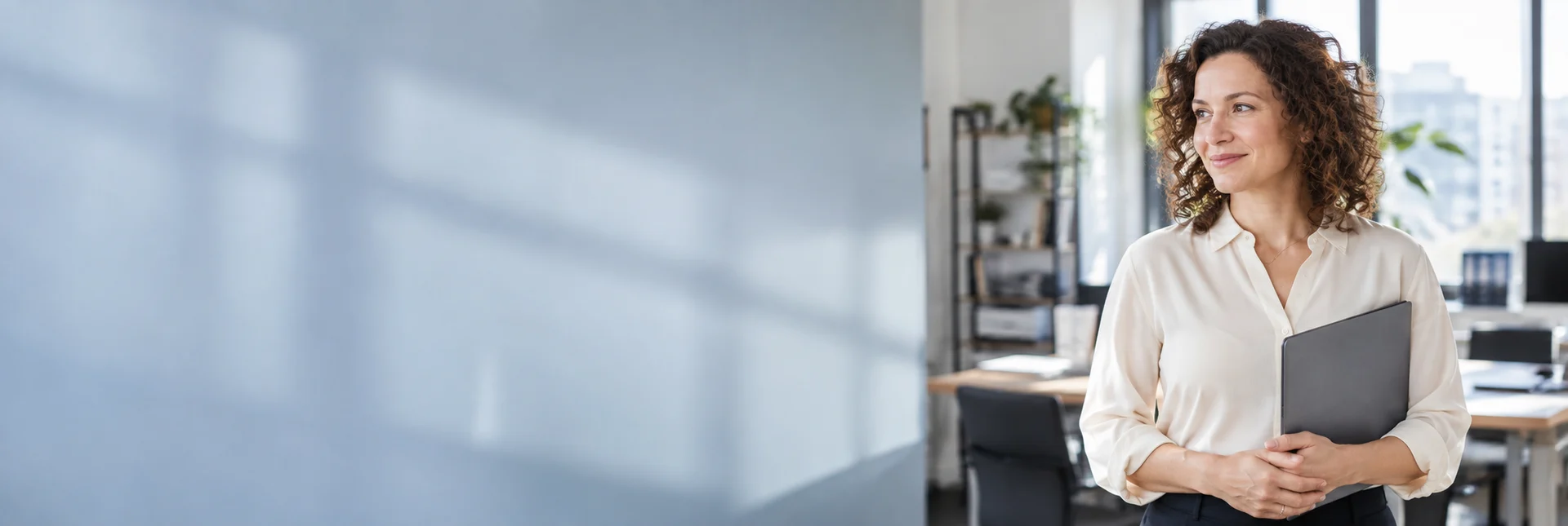 Friendly professional holding a folder in a bright office