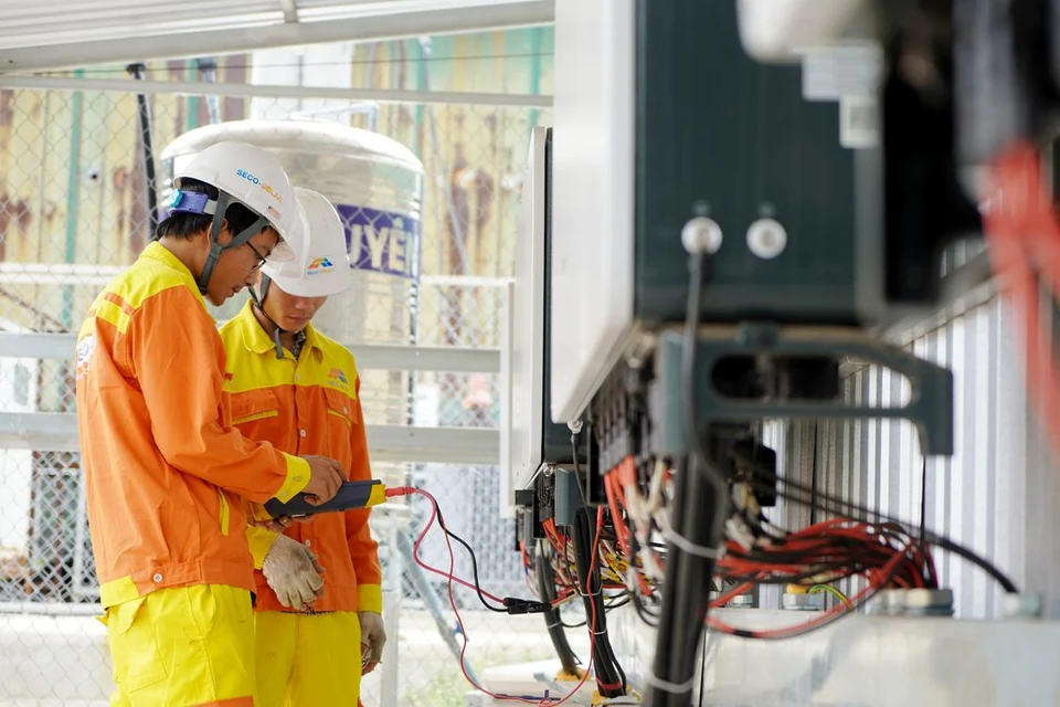 Two technicians checking electrical equipment at a work site